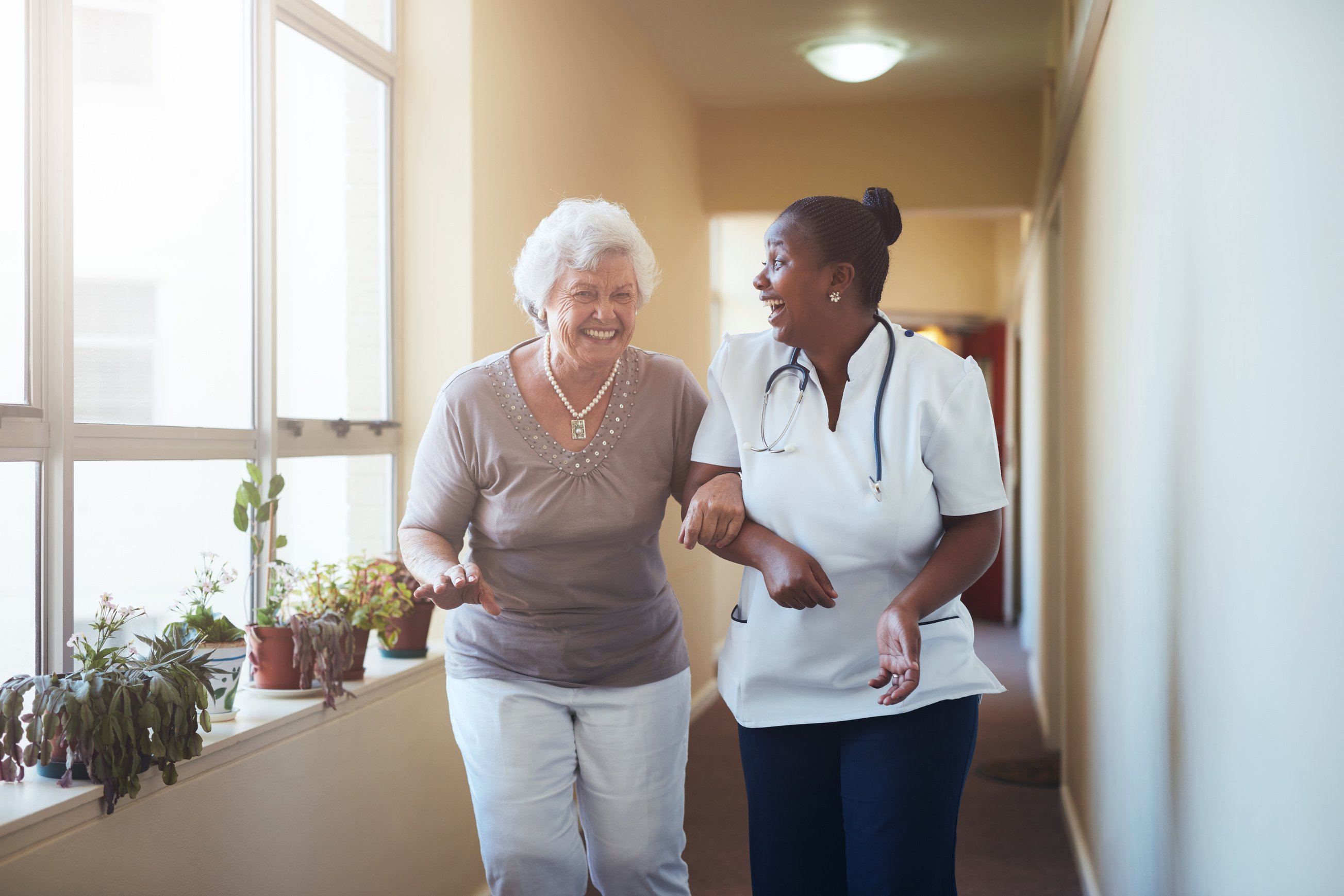 Happy Healthcare Worker and Senior Woman Talking Together